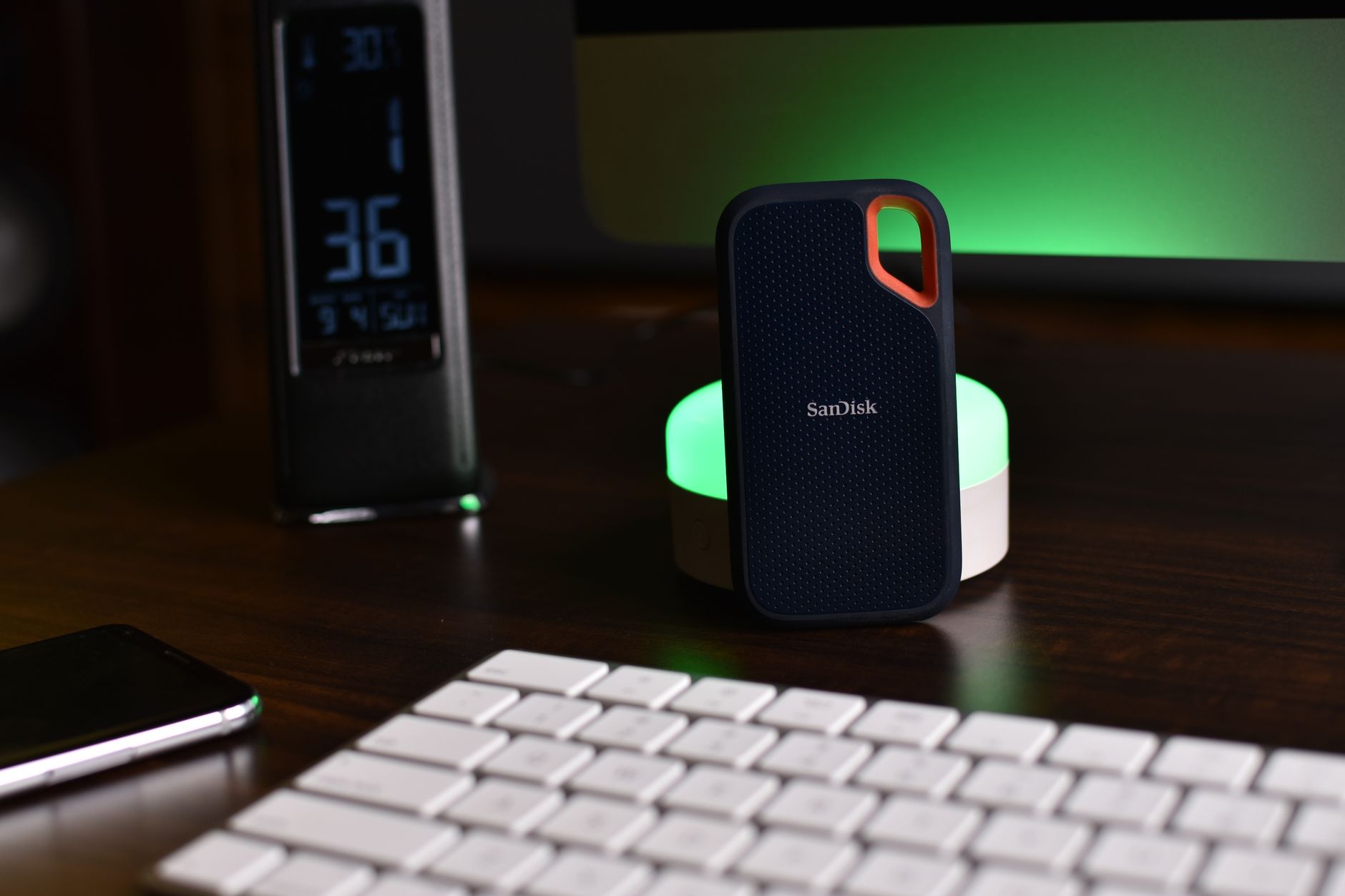 Stylish desk setup featuring a SanDisk external drive, keyboard, and ambient lighting.